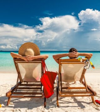 Retired couple sitting on deck chairs on the beach